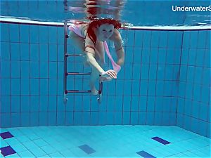 red-haired Simonna demonstrating her figure underwater